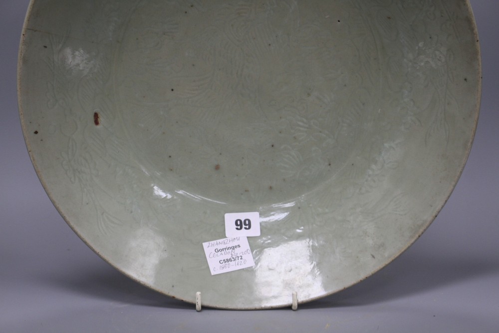 A Chinese Ming celadon dish, Zhangzhou kilns, c.1580-1620, incised with fish and water plants, diameter 38.5cm, height 8cm